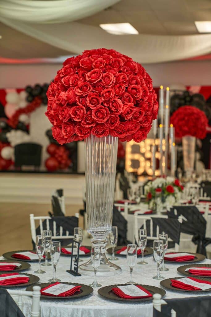 Tall red rose topiary centerpiece on a red, black and white table, October 2024
